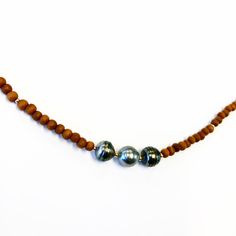 "Statement Alert This listing is for one amazing natural & organic sandalwood necklace. Fragrant Sandalwood bead necklace with three Tahitian Pearls & 14k gold fill spacers throughout. One of a kind beaded necklace, each one will slightly vary as no two pearls or beads are the same. Necklace measures approx. 16\" in length and is optional to add a adjuster chain of 3\" as needed. Perfect earthy necklaces that will stand out among them all. Please note: Because all pearls are unique, you Brown Wooden Beads Holistic Necklace, Holistic Brown Necklaces With Wooden Beads, Brown Spacer Beads Jewelry For Meditation, Natural Wood Jewelry With Wooden Beads For Meditation, Earthy Wooden Beads Jewelry For Meditation, Brown Holistic Jewelry With Wooden Beads, Tahitian Pearls Jewelry, Earthy Necklace, Tahitian Pearl Necklace