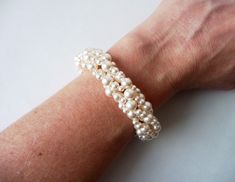 This bracelet is completely handwoven in your choice of Swarovski white or cream/ivory pearls. ~1/2 INCH EXTENSION INCLUDED ~ For adjustable sizing, embellished with silver heart charm ~Width Approximately 3/4 inch~ ♥ All jewelry comes in a gift box and is ready to give, at no additional cost! ♥ --------- ::BRACELET SIZE:: How to measure - Wrap a measuring tape around the wristbone lightly. Add one of the following sizes listed below to your measurement to determine the bracelet size you'll need Beaded Pearl Bracelet For Anniversary, Wedding Pearl White Beaded Bracelets, Handmade Pearl Bracelet For Wedding, Wedding Pearl Bracelet With Beaded Details, Cream Beaded Bracelets For Wedding, White Jubilee Beaded Bracelet For Wedding, White Beaded Jubilee Bracelet For Weddings, Pearl Beaded Bangle Bracelets For Wedding, White Pearl Beaded Bracelet For Wedding