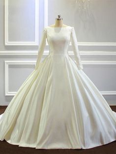 a white wedding dress on display in front of a chandelier