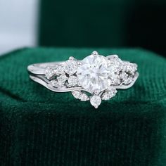 a diamond ring sitting on top of a green velvet cushion