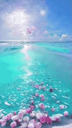 pink flowers are floating in the water on an ocean beach with blue sky and clouds