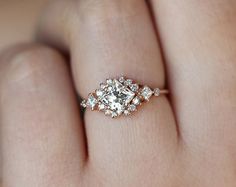 a woman's hand with a diamond ring on top of her finger and an engagement band