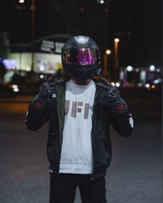 a person wearing a helmet and jacket standing in the street