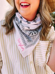 a woman wearing a straw hat and scarf with her hand on her hip, smiling