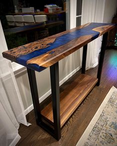 a wooden table sitting on top of a hard wood floor next to a white rug