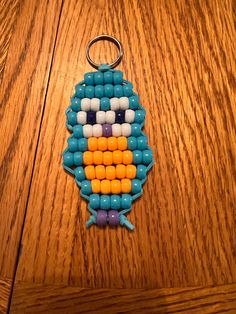 a keychain made to look like a bird with beads on it's face