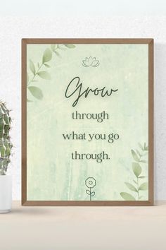 a green poster with the words grow through what you go through on it next to a potted plant