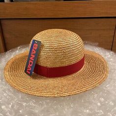 a straw hat with a red ribbon around the brim