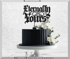 a black cake with white flowers on top and the words happily yours written in cursive font