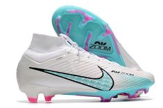 a pair of white and blue soccer shoes with pink accents on the soles, against a white background