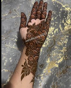 a woman's hand with henna tattoos on it