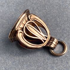 "What a gorgeous piece from the late-1800s to early-1900s! This fob shows a strong influence of Victorian design and the newer Art Nouveau and Arts & Crafts styles coming out at this time. The gold is a soft rosy tone of 12 karat that was popular in British jewelry. The seal is a faceted Quartz with a foil back and the neatest carving of stag heads and flaming hills in a crest. The ring the fob hangs from is antique gold-filled ant the fob is quite hefty. It is a well-made piece with a whole Stag Head, 18k Gold Earrings, Sparkling Stars, Arts Crafts Style, Victorian Design, Charm Chain, Vintage Pendant, Gold Flakes, Early 1900s