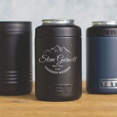 three black and blue canisters sitting on top of a wooden table next to each other