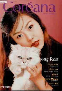 a woman holding a white cat on top of a magazine cover