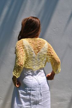 Sweet and simple little yellow shrug for summer days when all you need is a light weight cover-up to cover shoulders and upper arms. I hand knit this item with a cotton viscose ethically sourced yarn. It is very soft and comfortable. The open-net/loose-knit style will keep you cool but still giving you the coverage you need. Hand knitted shrug Sleeve length: Half sleeve, reaches half way between elbows and wrist. Color: Soft Yellow Ecru/Ivory Taupe/beige with specks of yellow Size: Small, Medium Long Sleeve Shrug For Spring Beach Outings, Beach Open Knit Shrug, Open Knit Summer Shrug For Beach, Open Knit Shrug For Summer Beach, Summer Long Sleeve Open Knit Shrug, Summer Beach Open Knit Shrug, Stretch Open Knit Cover-up For Spring, Summer Long Sleeve One-size Shrug, Long Sleeve Crochet Shrug For Summer