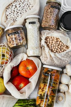 various types of food are in bags on the table, including asparagus and tomatoes