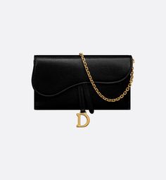 The Saddle pouch with chain, crafted in black goatskin, is a hybrid creation with a both modern and streamlined design. The accessory has an asymmetrical flap featuring an antique gold-finish metal D stirrup. Thanks to its detachable chain strap, the small pouch may be worn over the shoulder, crossbody or carried by hand.. Dior Saddle Wallet On Chain, Dior Wallet On Chain, Saddle Pouch, Wallet With Chain, Aesthetic Clothing Stores, Best Wallet, Dior Couture, Dior Wallet, Stirrups