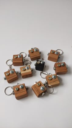 eight wooden key chains with metal snaps and eyeballs on them, all in different shapes and sizes