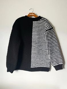 a black and white sweater hanging on a hanger, with the same color as it is