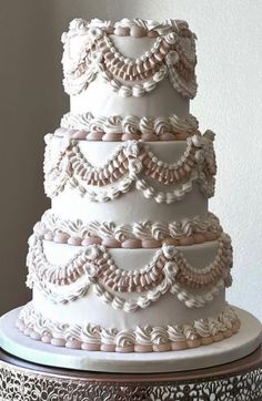 a three tiered wedding cake with white icing and ruffles on top