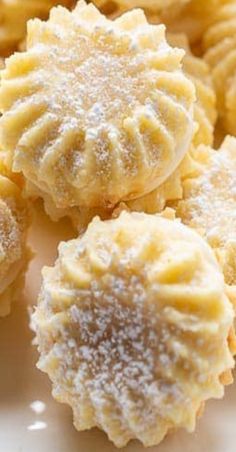 some cookies are on a white plate with powdered sugar