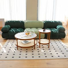 a living room with two green couches and a coffee table in front of them