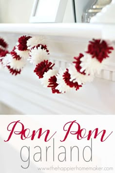 some red and white pom pom garland hanging from the mantle