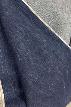 the back pocket of a blue jean jacket with white stitching on it and an open zipper