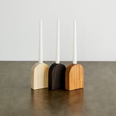 three wooden candlesticks sitting next to each other on a table