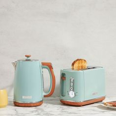 two toasters sitting next to each other on top of a marble counter with food in front of them