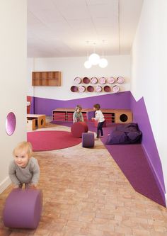 a child is sitting on a stool in the middle of a room with purple walls