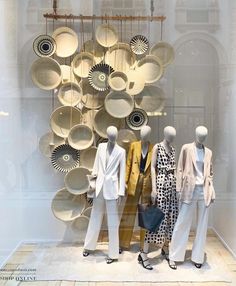 several mannequins are standing in front of plates and pans on display