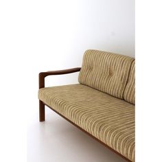 a brown and white striped couch sitting on top of a white floor next to a wall