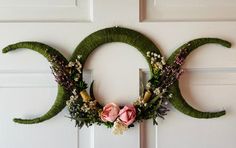 a wreath made out of grass with flowers on it