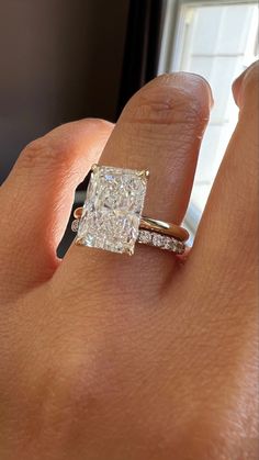 a woman's hand with a ring on it and a diamond in the middle