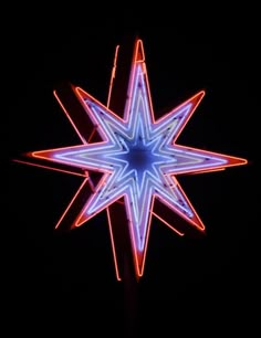 a blue and red lighted star in the dark