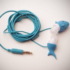 a pair of ear buds connected to a fish shaped headphone cord on a white surface