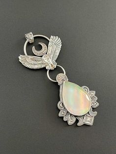 This is a solid silver owl soaring, and below it carries a gorgeous aurora opal. This is a synthetic type of opal, but they are very beautiful and have many flashing colors. This one has greens, blues, pinks, even purples among some other colors. The design is accented by hand stamped designs.  This pendant is solid sterling silver and is a handmade one of a kind piece. This is a beautiful piece, a statement, a talisman. It carries the energy of the owl.  This pendant does not come with a chain. Independent Thinking, Owl Accessories, Aurora Opal, Soldered Jewelry, Sterling Silver Owl, 3d Jewelry, Supernatural Power, Silver Owl, Owl Necklace