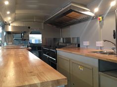 an empty kitchen with stainless steel appliances and wood counter tops in a commercial vehicle or camper