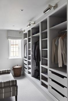 a large walk in closet with white walls and drawers