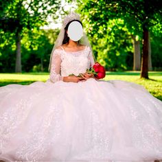 a woman in a wedding dress sitting on the ground