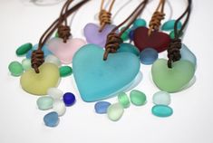 several different colored heart shaped glass beads on brown cord with string and bead ends