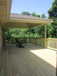 a wooden deck with two chairs on it