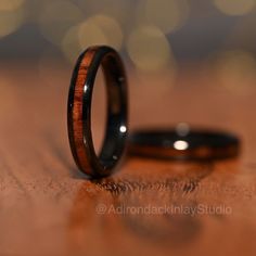 two wedding rings sitting on top of a wooden table