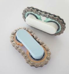 an old bicycle chain and roller blades on a white table with a light blue handle