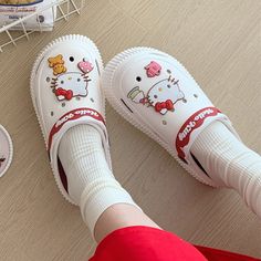 someone is wearing hello kitty shoes on the floor next to some donuts and cookies