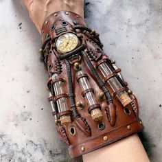 a person's hand with a wrist made out of leather and metal parts, holding a watch