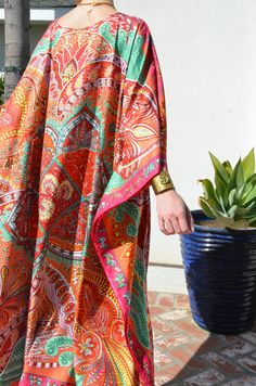 "This beautiful silk caftan is a design from Hermes called \"le Jardin de la Maharani Recadre\". It was designed as a tribute to Maharani of Jaipur who devoted her life to the support of the women of India. It is an intricate, mixed design with colors of orange, reds, green and pinks, with a pink border outlining it all. The generous amount of silk fabric adds to its elegance and beautiful flow. Appropriate for so many occasions. One size. It fits many sizes from small to X-Large. The width, edg Silk Tunic Kaftan For Festivals, Bohemian Silk Kaftan For Beach Cover-up, Bohemian Silk Kaftan With Kimono Sleeves, Bohemian Silk Kaftan With Vibrant Print, Silk Multicolor Beachwear Kaftan, Bohemian Silk Tunic With Kimono Sleeves, Multicolor Silk Kaftan For Beachwear, Vibrant Silk Kaftan, Bohemian Multicolor Kaftan