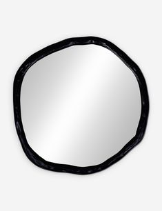 a mirror that is on the wall with a black frame and an oval shaped design