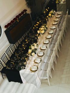 a long table is set with white and gold plates